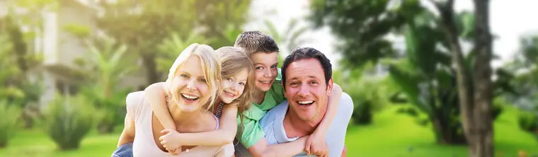 Família sorrindo abraçada num gramado